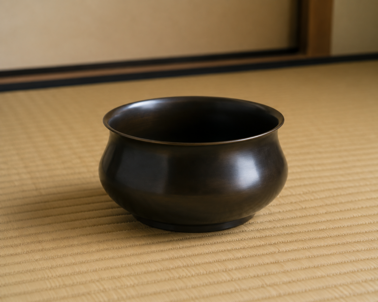 畳の上に置かれた黒い建水。捨てる水を受け止め、茶席を静かに支える道具